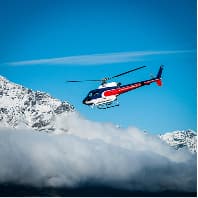 Helicopter flying over snowy mountains